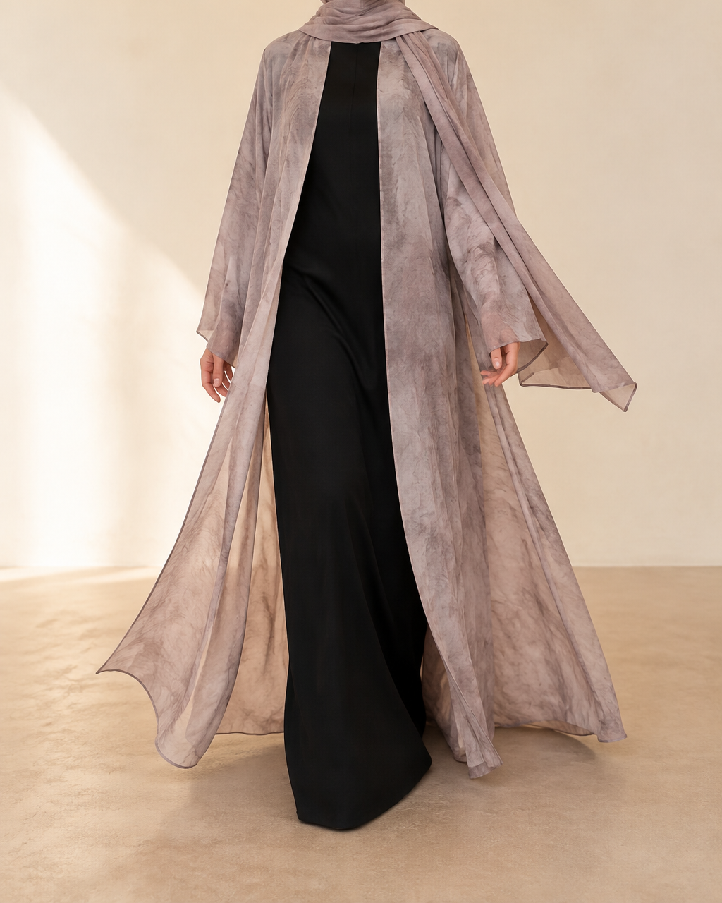 Sama printed abaya in Taupe — mid-stride, panels in motion, worn open over a black inner, matching shayla